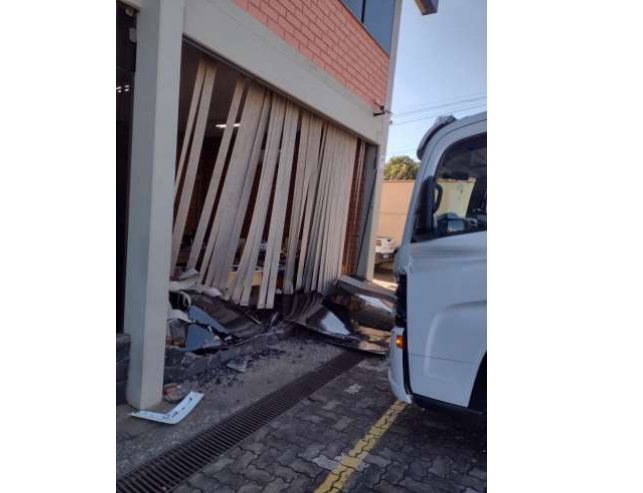 Ré desengata e caminhão bate em fachada de empresa