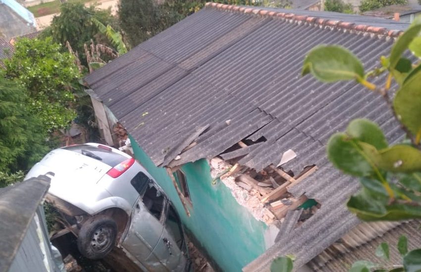  Carro cai em telhado de residência