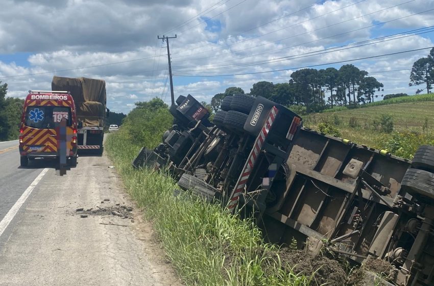  Motorista fica ferido após caminhão sair da pista e tombar