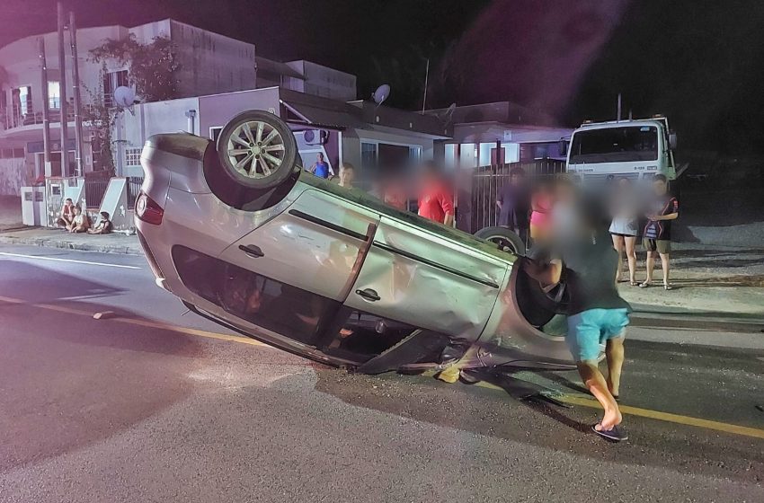  Carro capota após bater em veículo estacionado